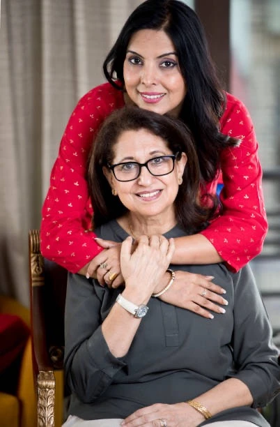 An Indian daughter in red hugging her mother