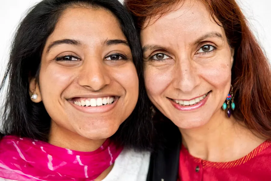 A mother and daughter, cheek to cheek, smiling